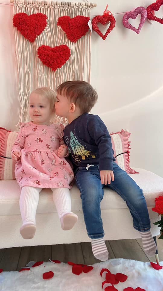 Child kissing another child on the cheek