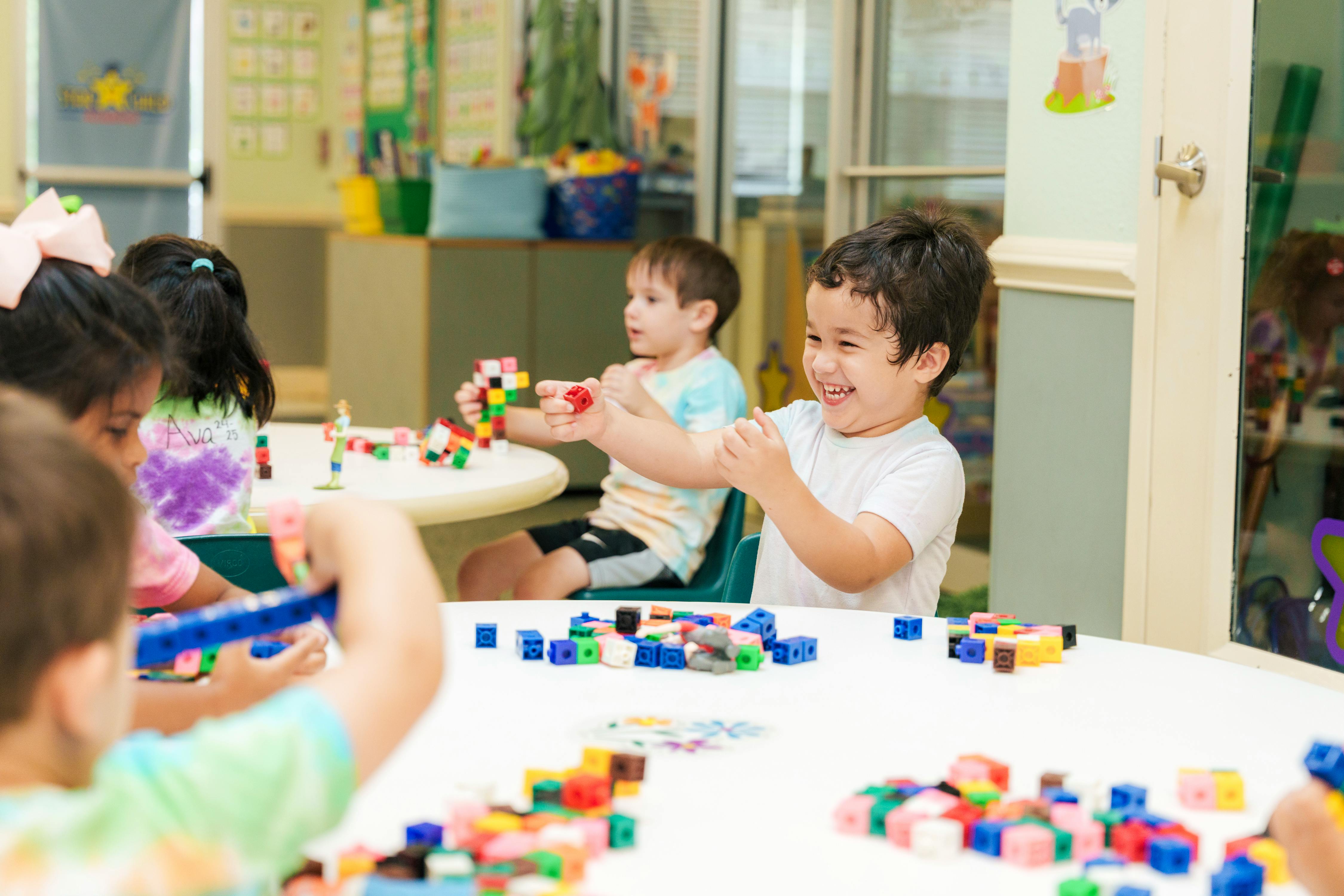Children playing with colorful building blocks at a table