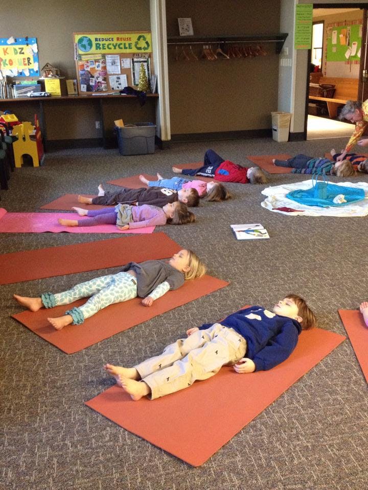 Children lying on yoga mats on the floor