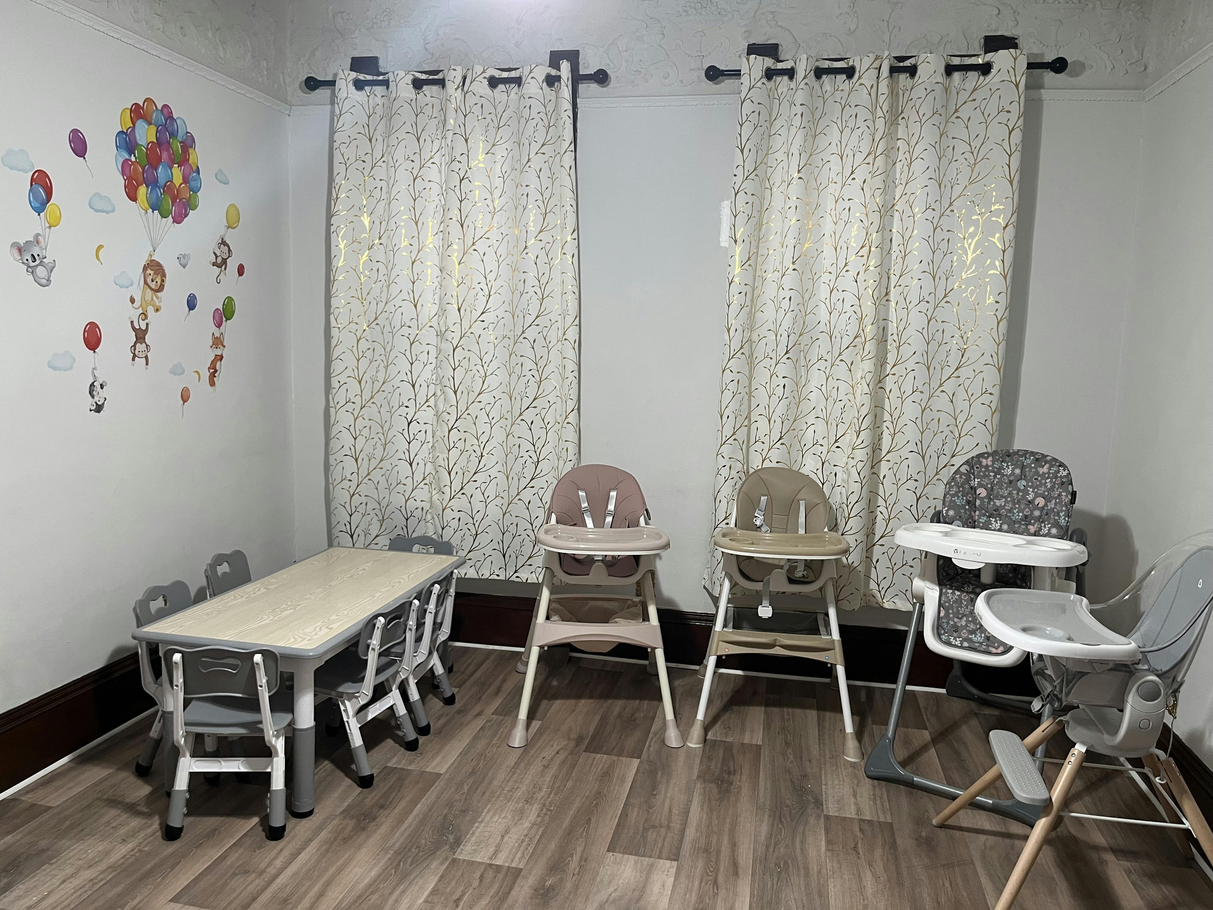 Children's table with chairs and multiple high chairs in a room