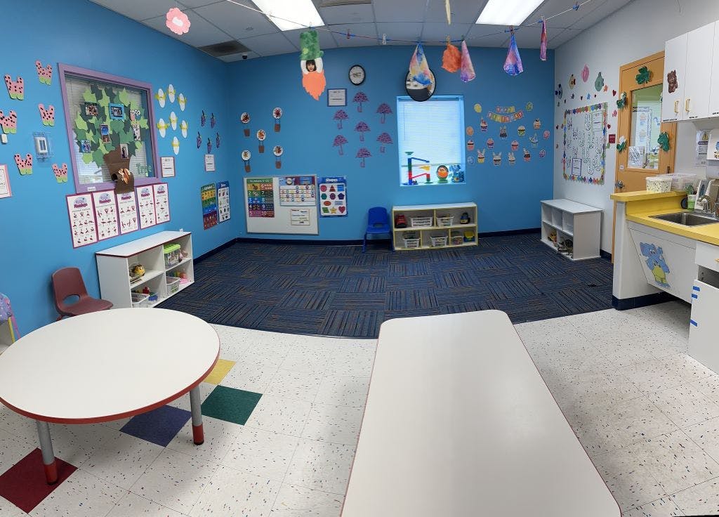 Empty classroom with blue walls and a play kitchen