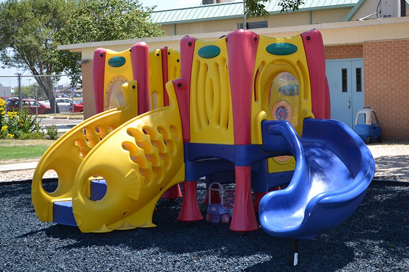 Playground structure with yellow slides and a blue slide