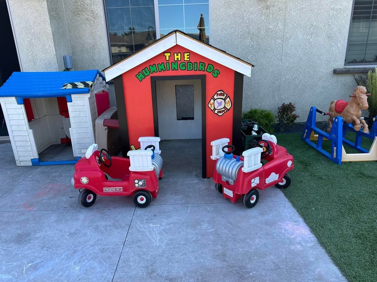 Playhouses and ride-on toys in an outdoor play area