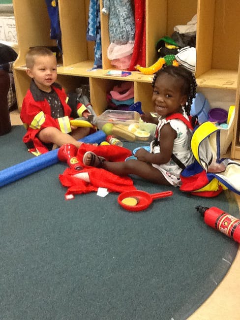 Two children playing on the floor with toys