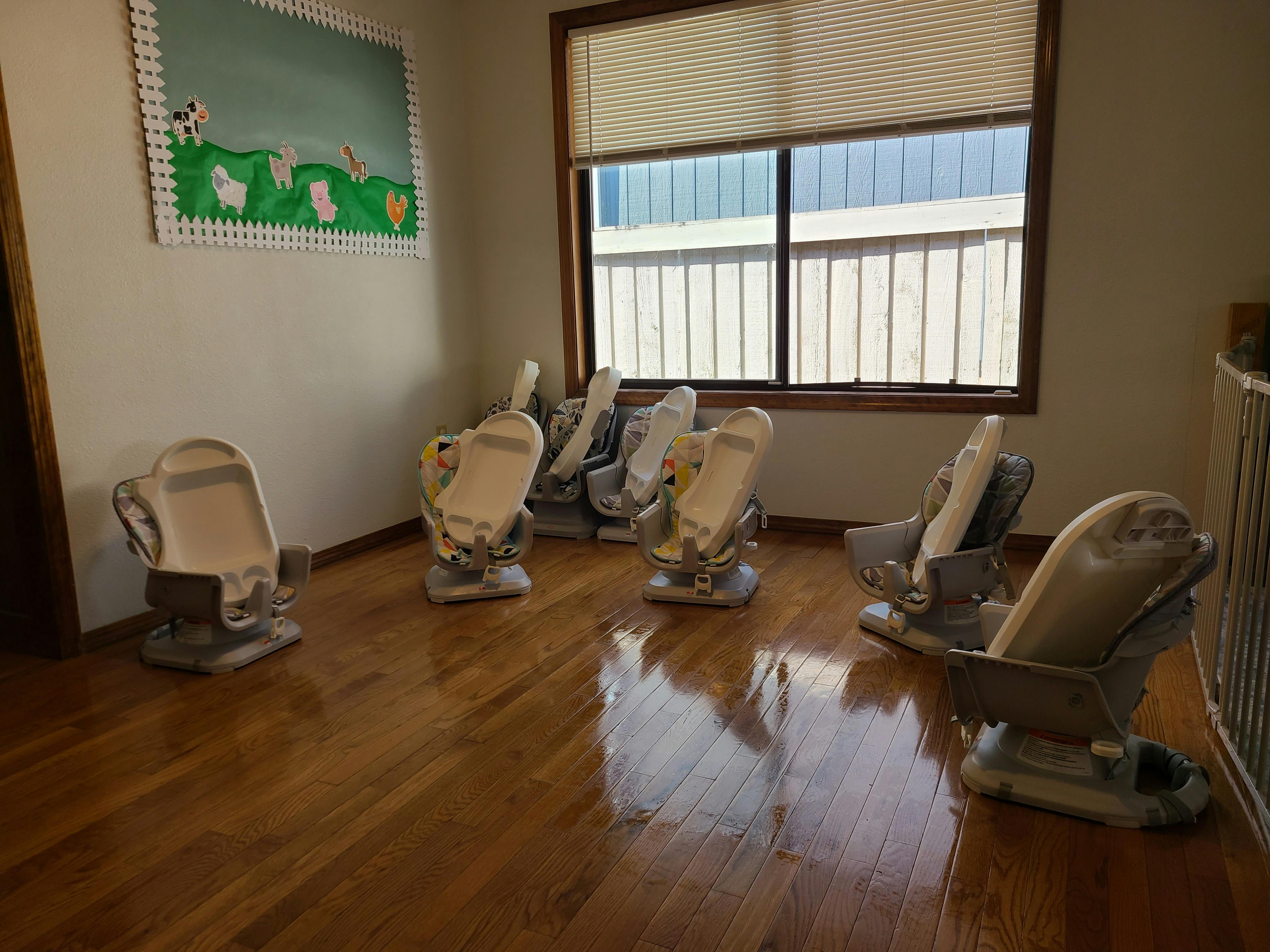 Room with multiple dental chairs arranged on a wooden floor