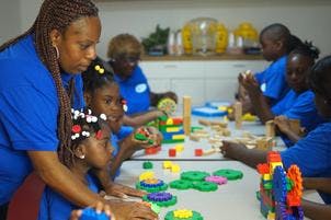 Adult and children building with blocks at a table