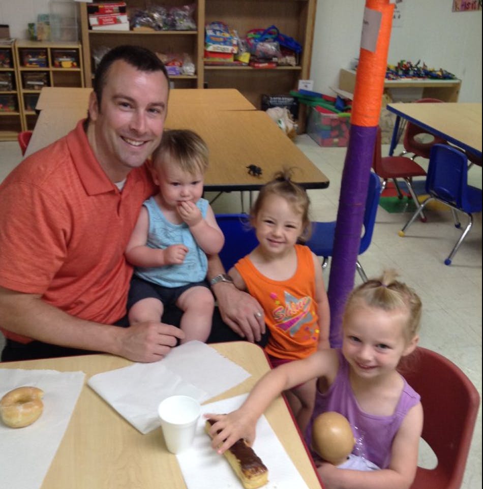 Person with three children at a table with pastries