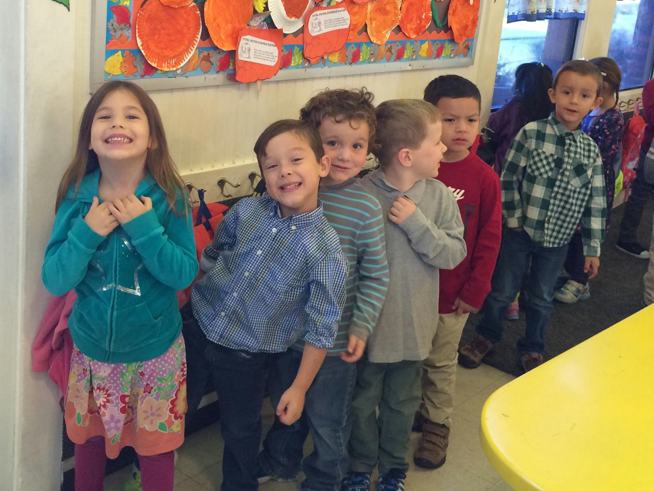 Group of children standing in a line in a classroom