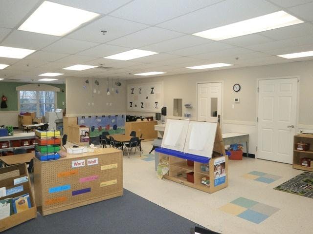 Empty classroom with tables, chairs, and learning materials