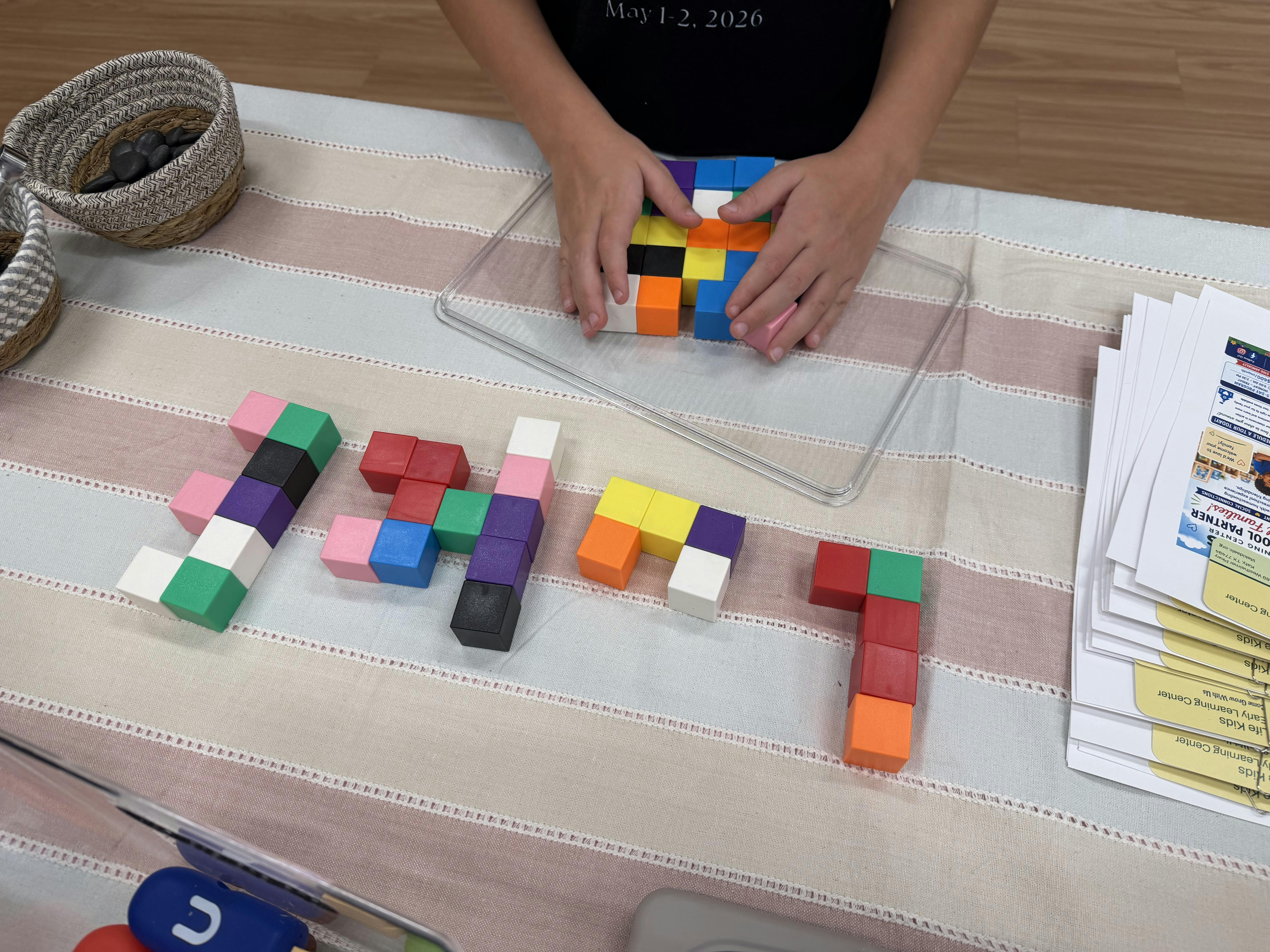 A person arranging small colorful blocks on a table