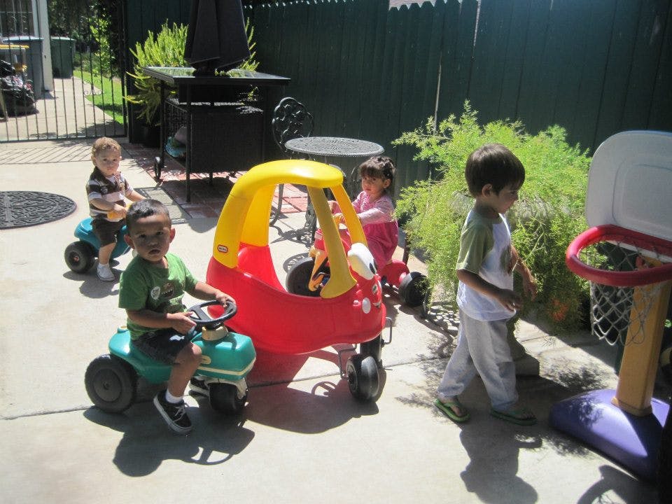 Children playing with ride-on toys outdoors