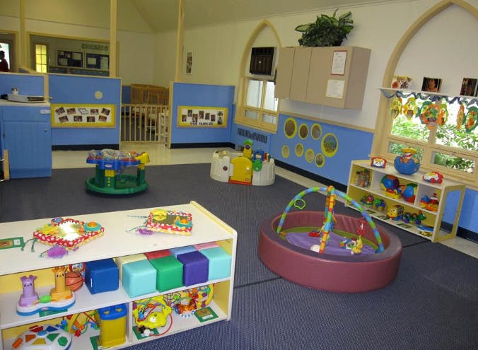 A colorful childcare room with various toys and play equipment