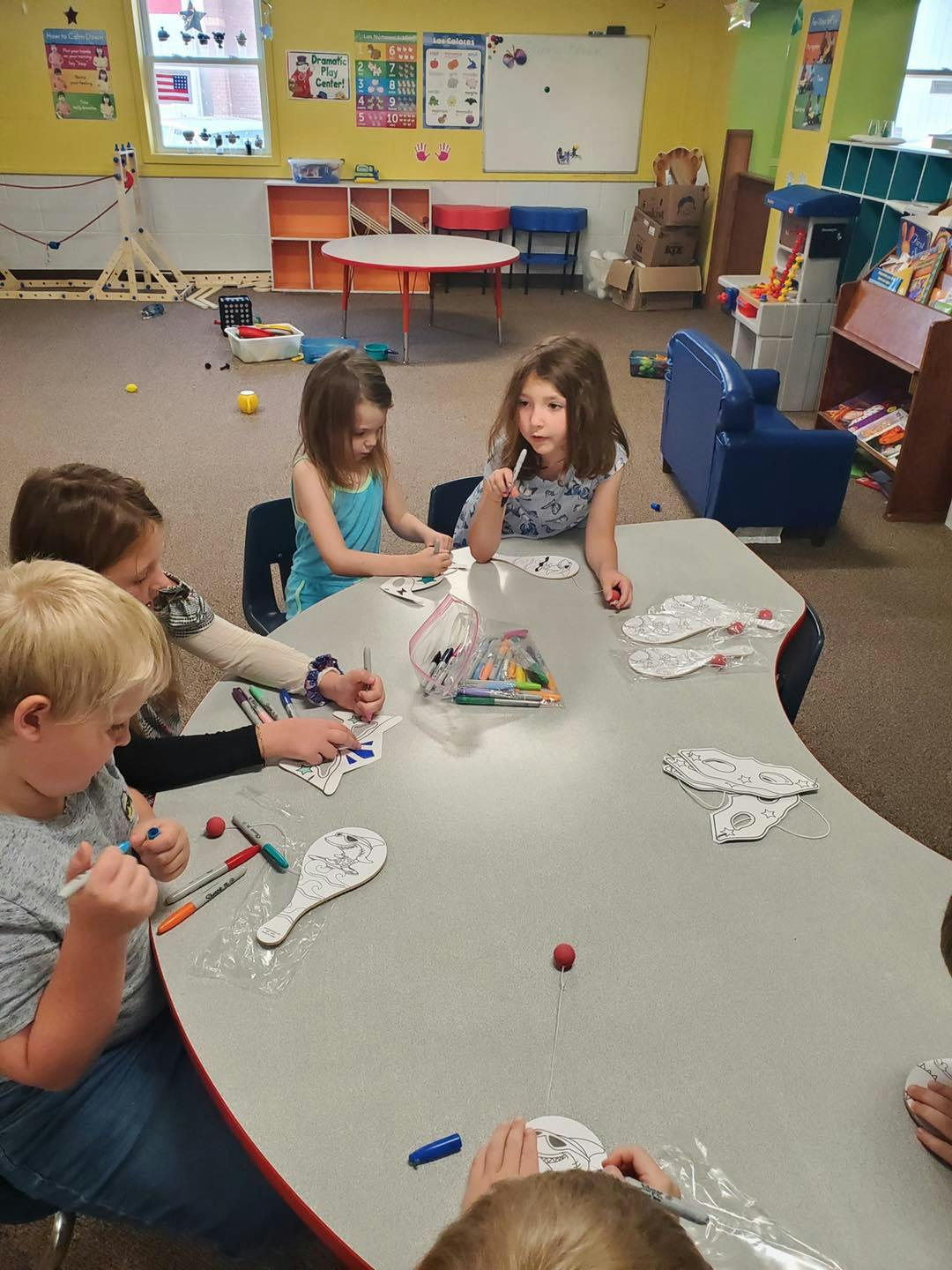 Children coloring at a table in a classroom