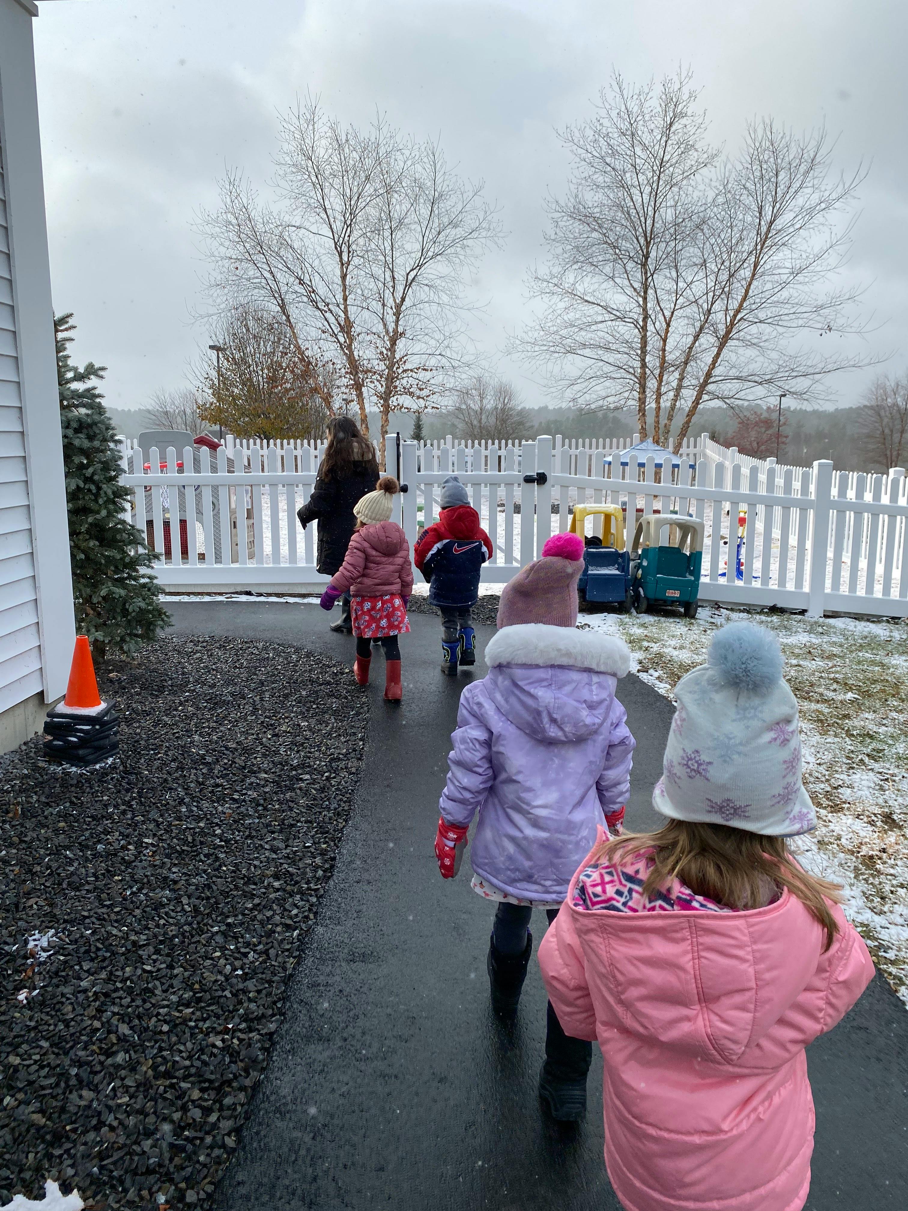 A person and children walking on a path outdoors in winter