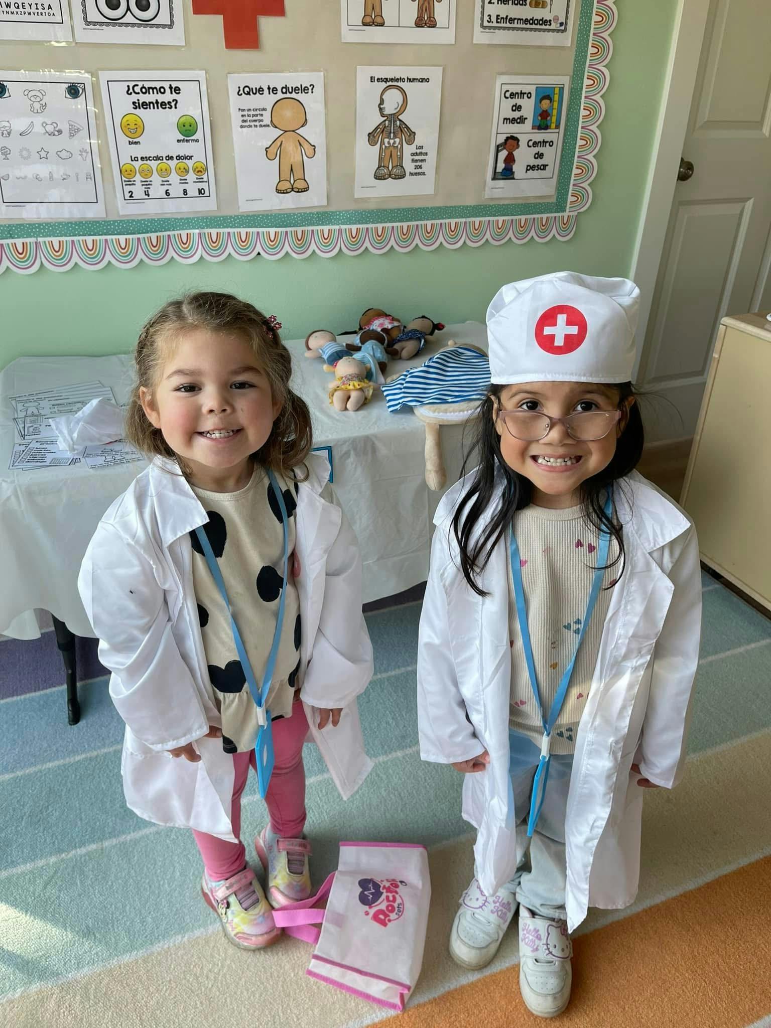 Two children dressed in white lab coats, one wearing a nurse's cap