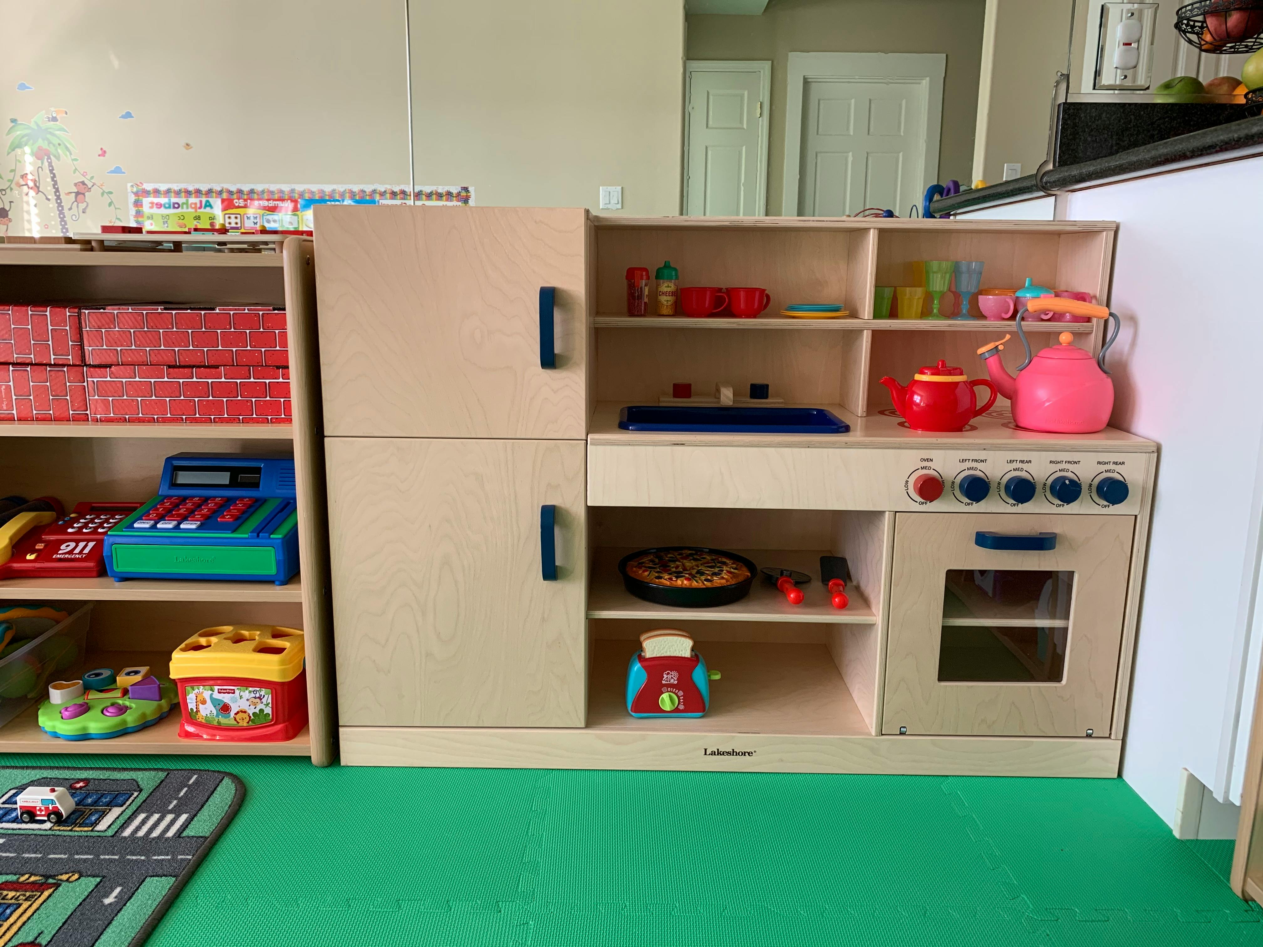 Toy kitchen set with refrigerator, stove, and oven