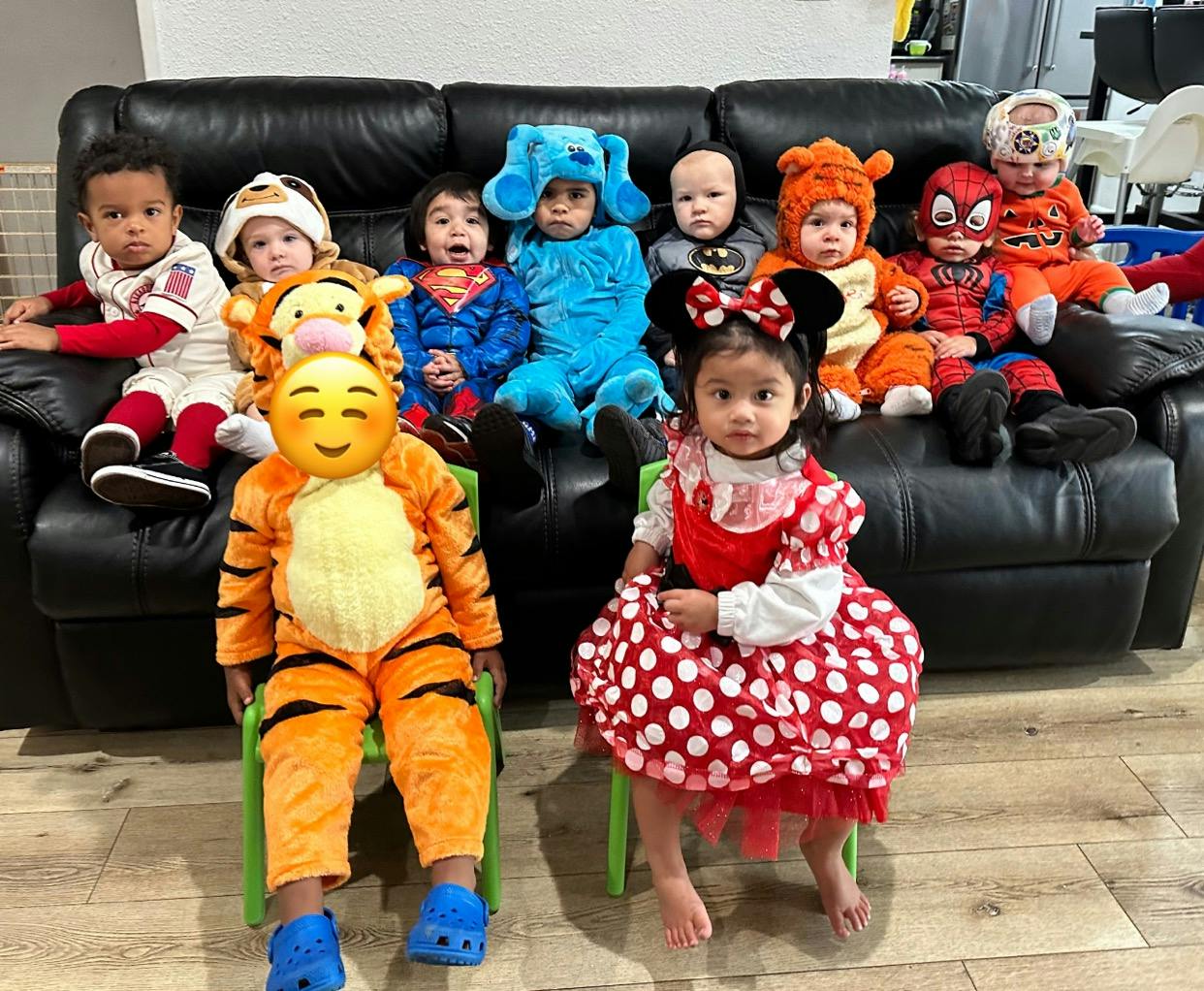 Children in various costumes sitting on a couch and chairs