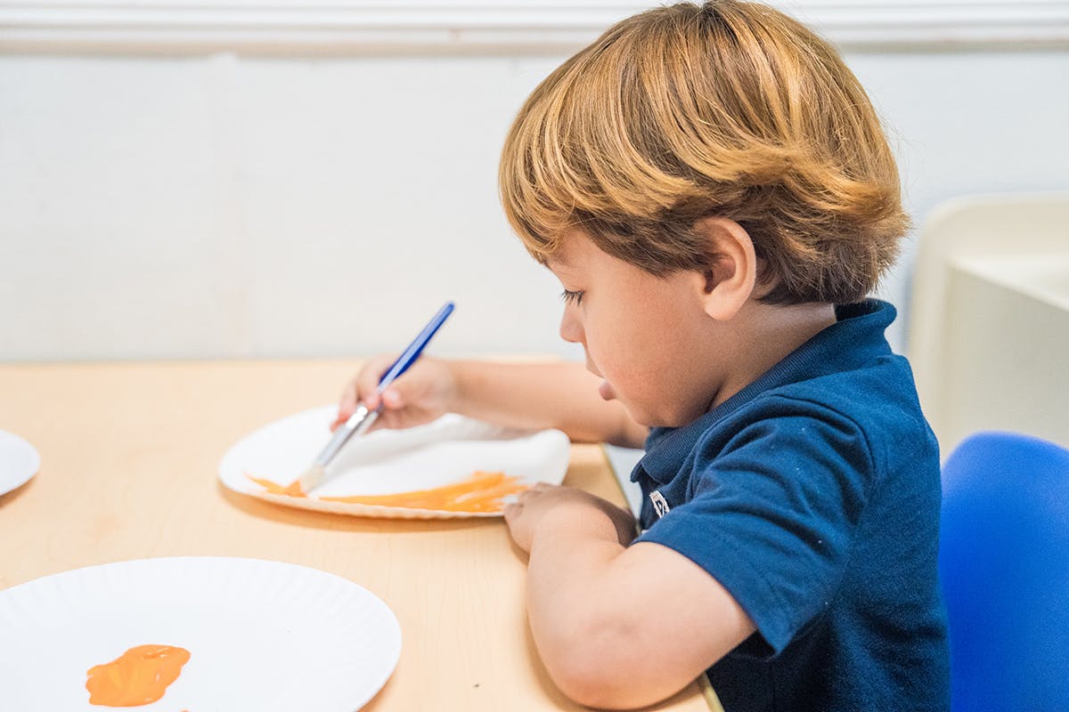 Child painting on a plate atable