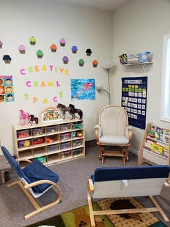 Child's play area with shelves, chairs, and wall decorations