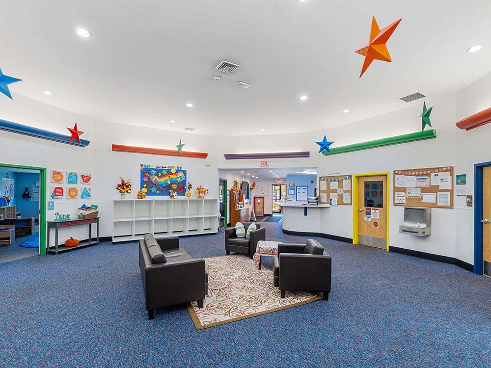 Lobby of a daycare center with a reception desk and seating area