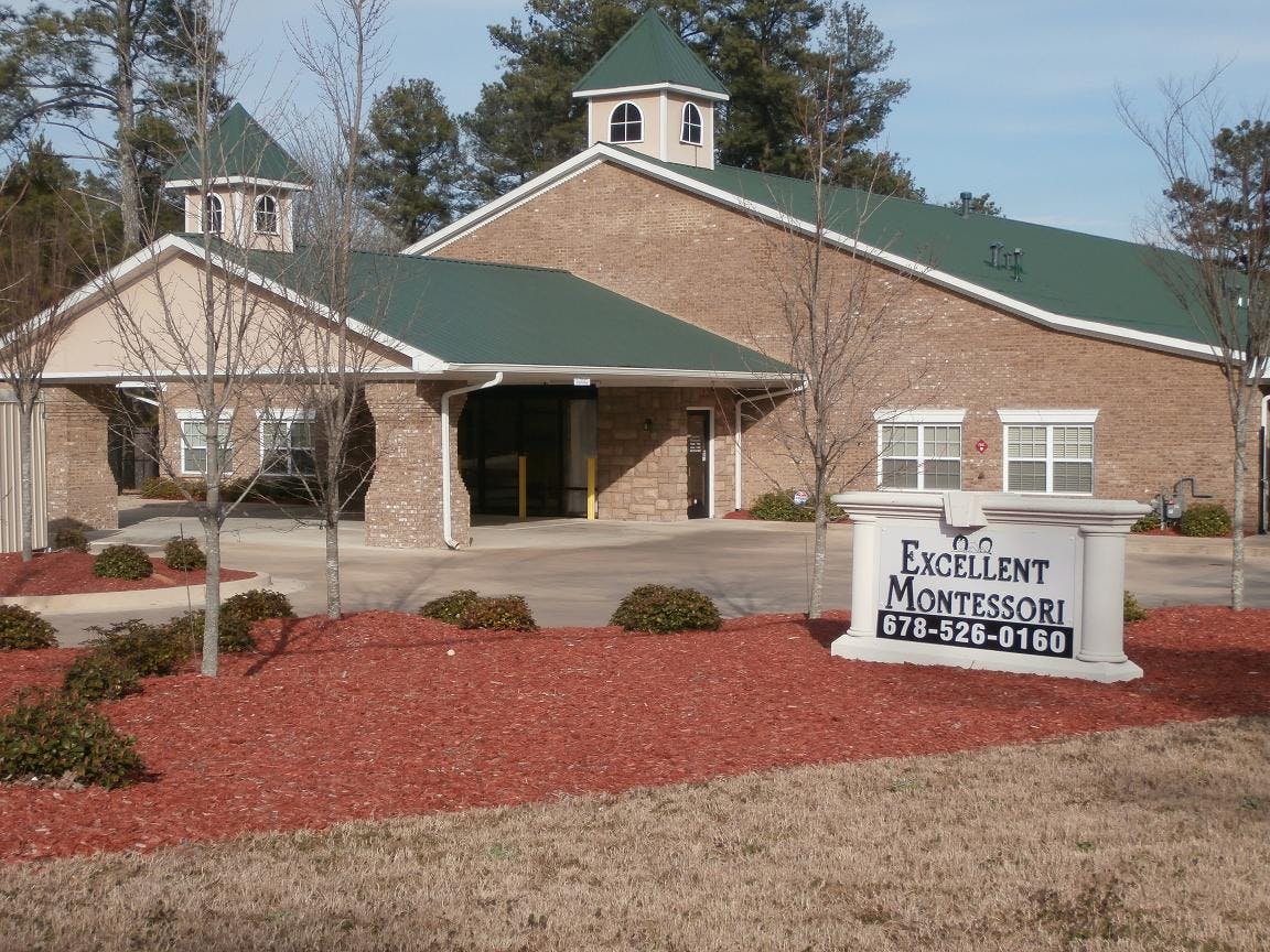 Building with green roof and a sign that reads Excellent Montessori