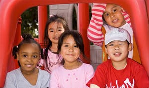 Five children in a red play structure
