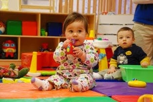 Two children playing on a mat in a room