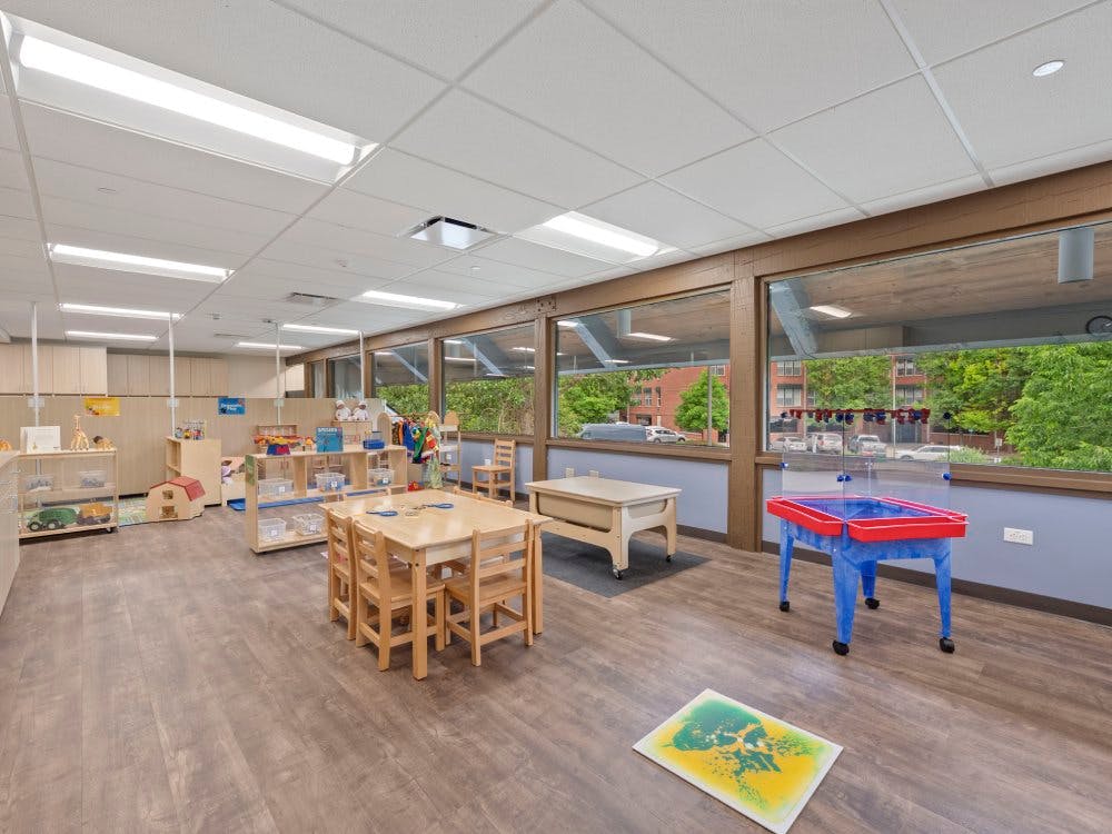 Empty classroom with small tables, chairs, and activity stations