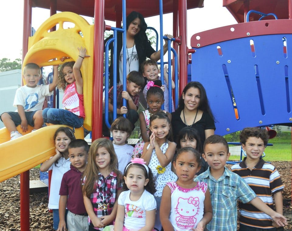 Adults and children on a playground structure in a playground structure