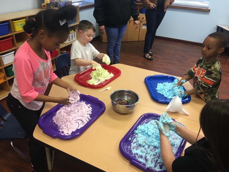 Children playing with colorful foam at a table