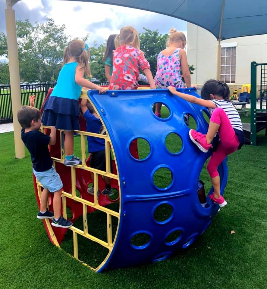 Children climbing on a blue and red playground structure