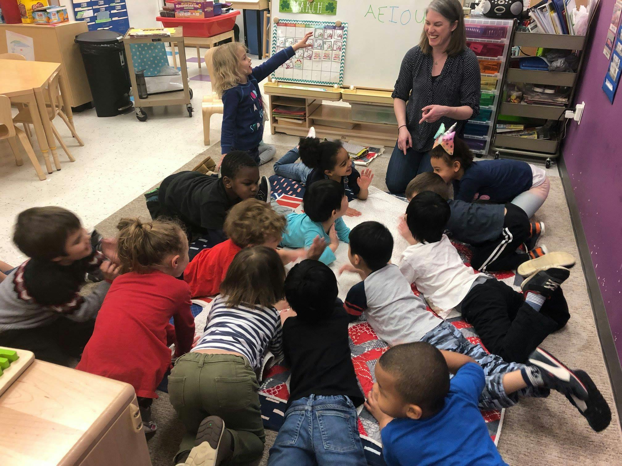 Adult and children on floor in classroom