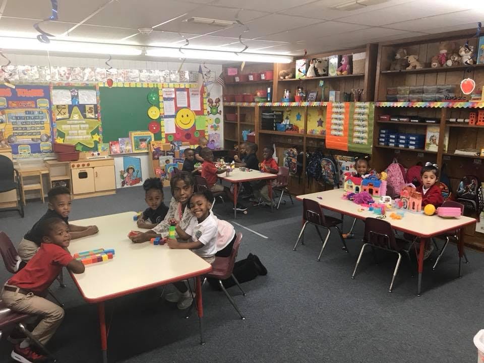 Children sitting at tables in a classroom