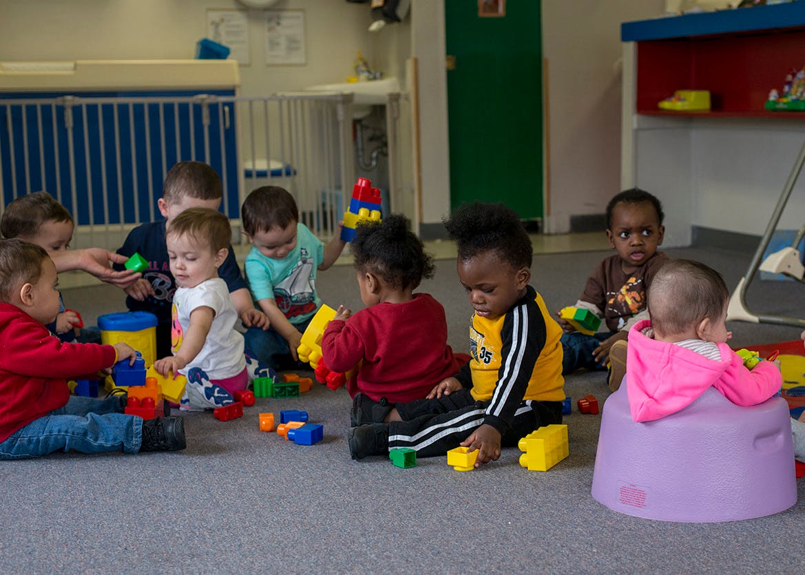 Children playing with blocks on the floor in a classroom