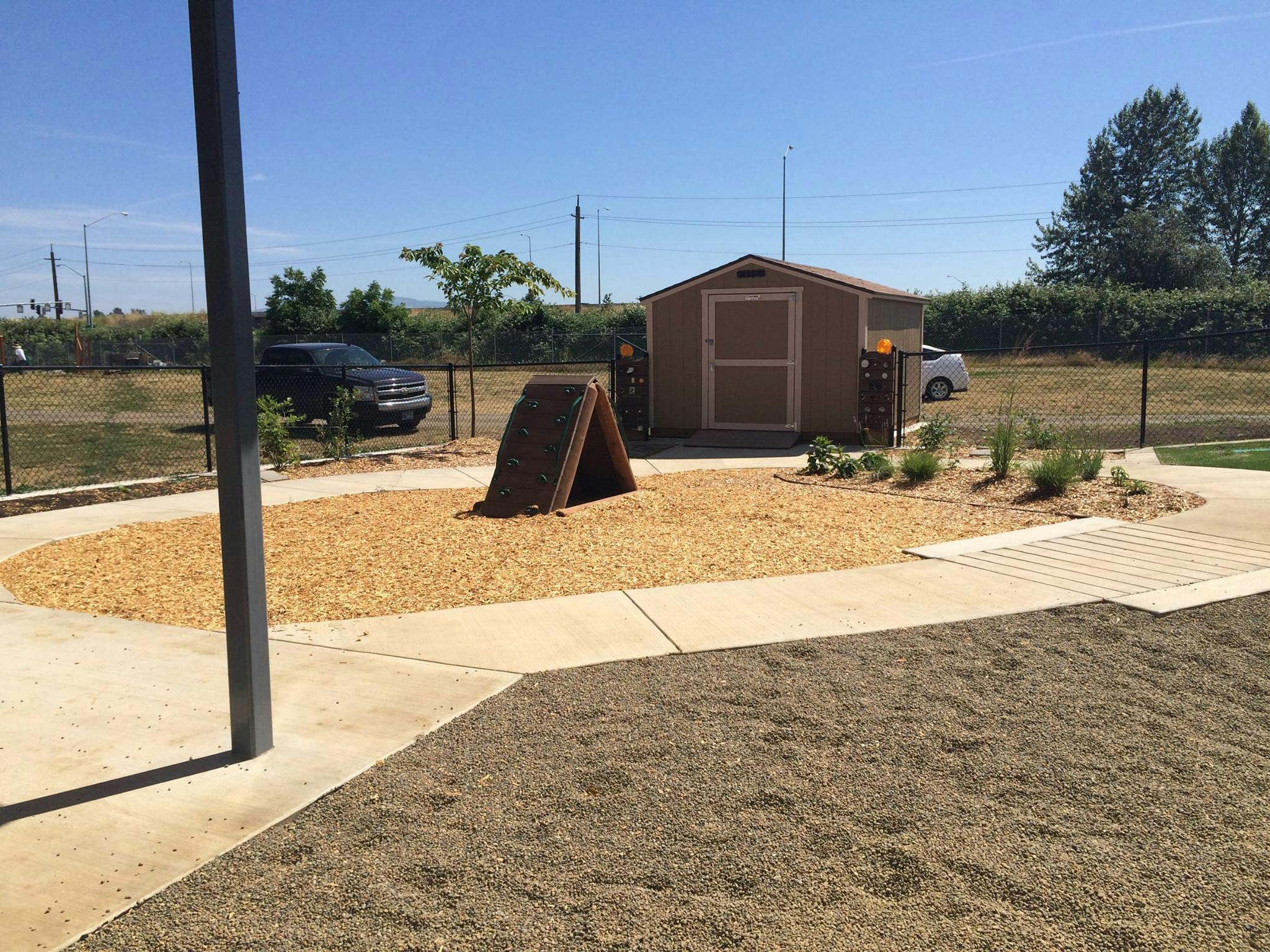 Outdoor area with a small shed, wood chips, and a-frame structure
