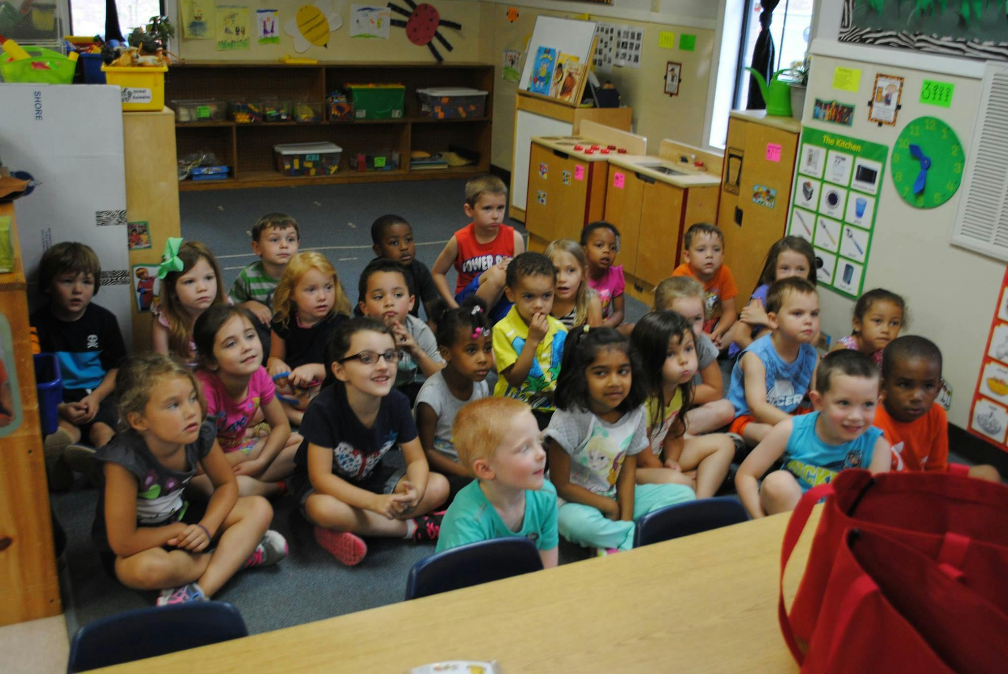 Group of children sitting on the floor in a classroom