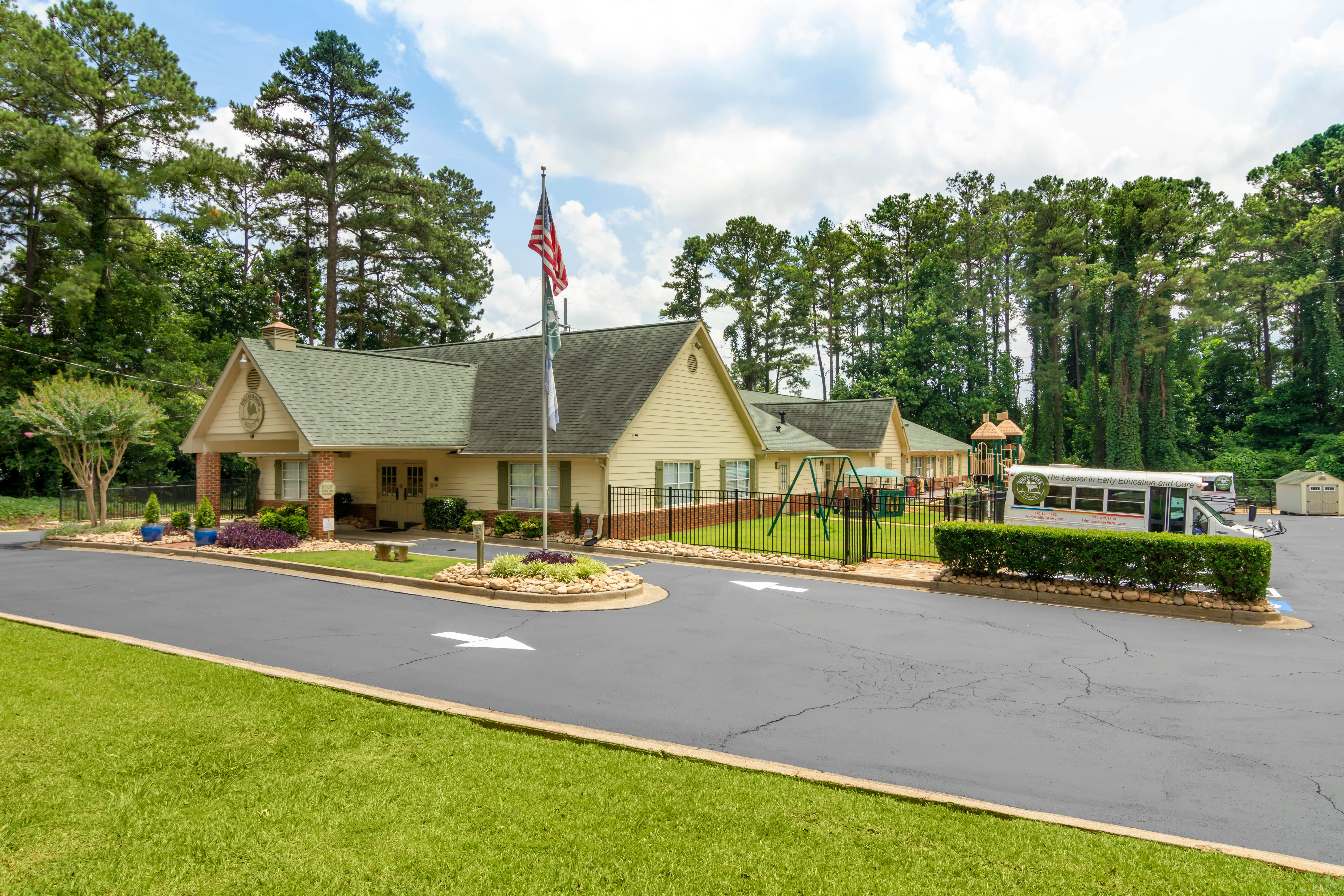 An outdoor daycare or school building with a small playground and a bus