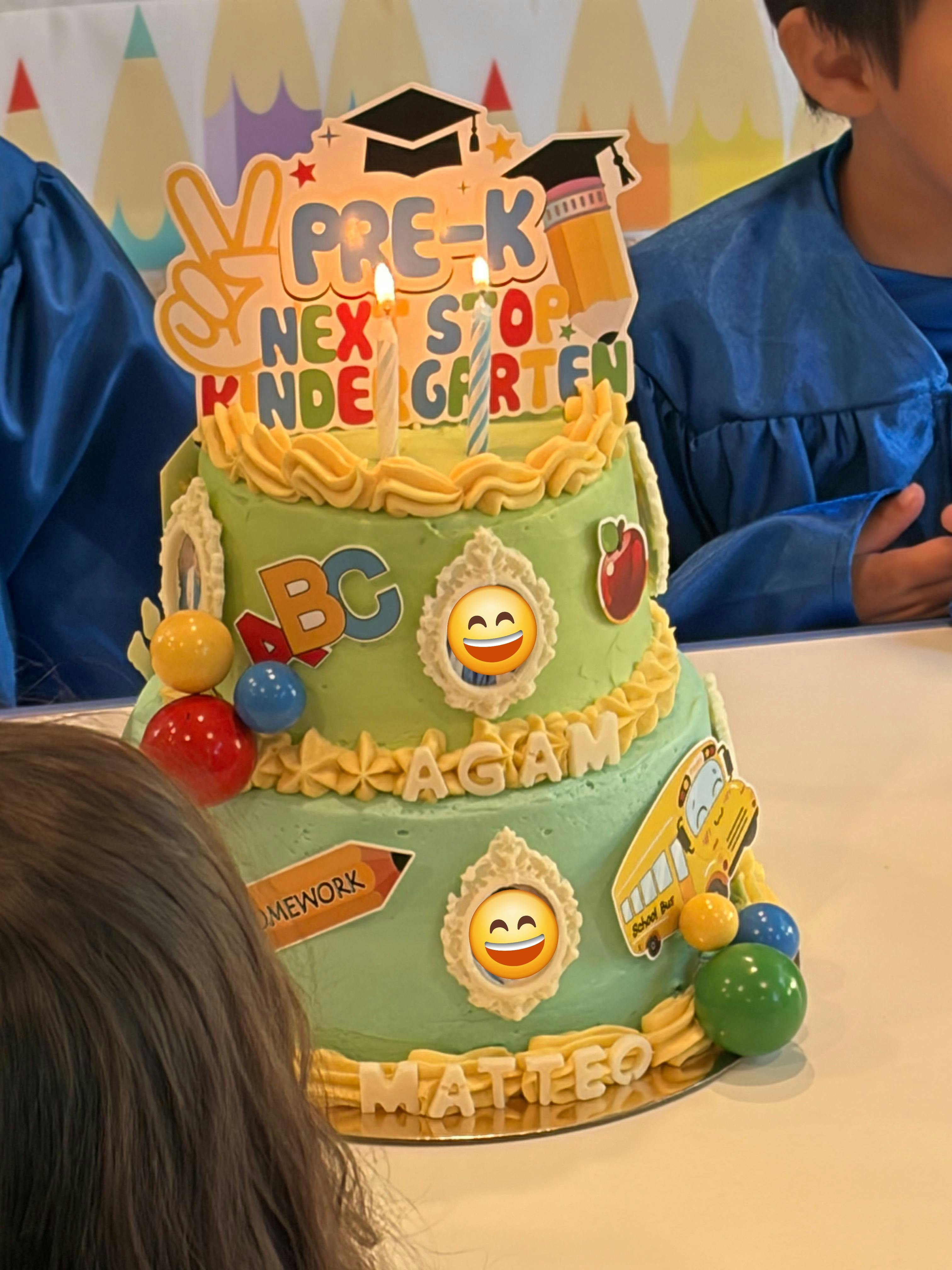 Tiered Pre-K graduation cake decorated with school themed toppers and candles