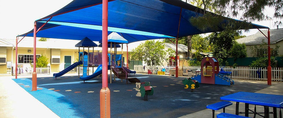 Playground with blue shade structure and play equipment
