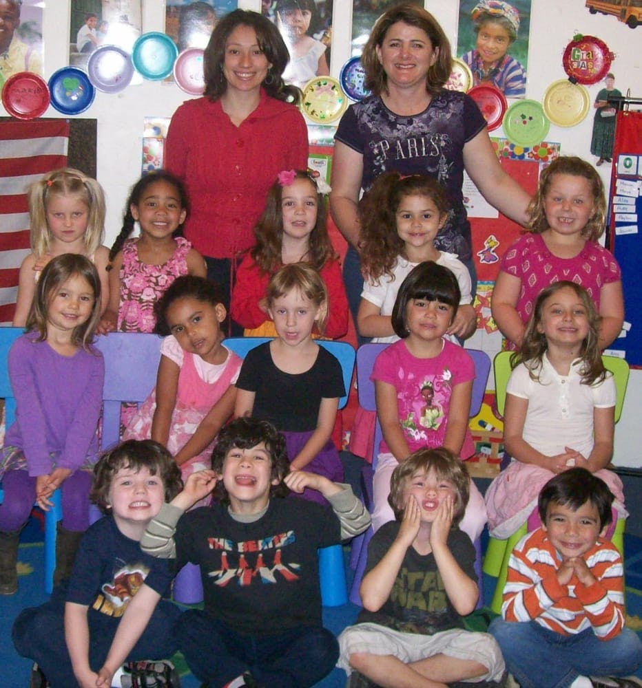 Two women and a group of children posing for a photo