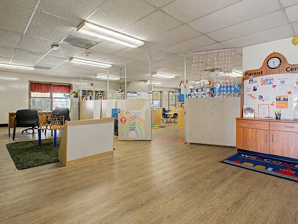 An empty childcare center classroom with learning areas