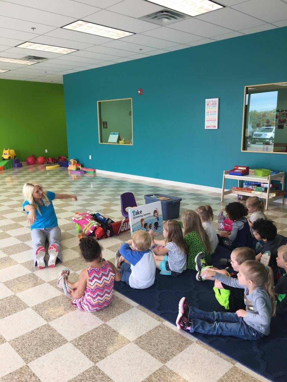 Adult and children sitting on floor in classroom