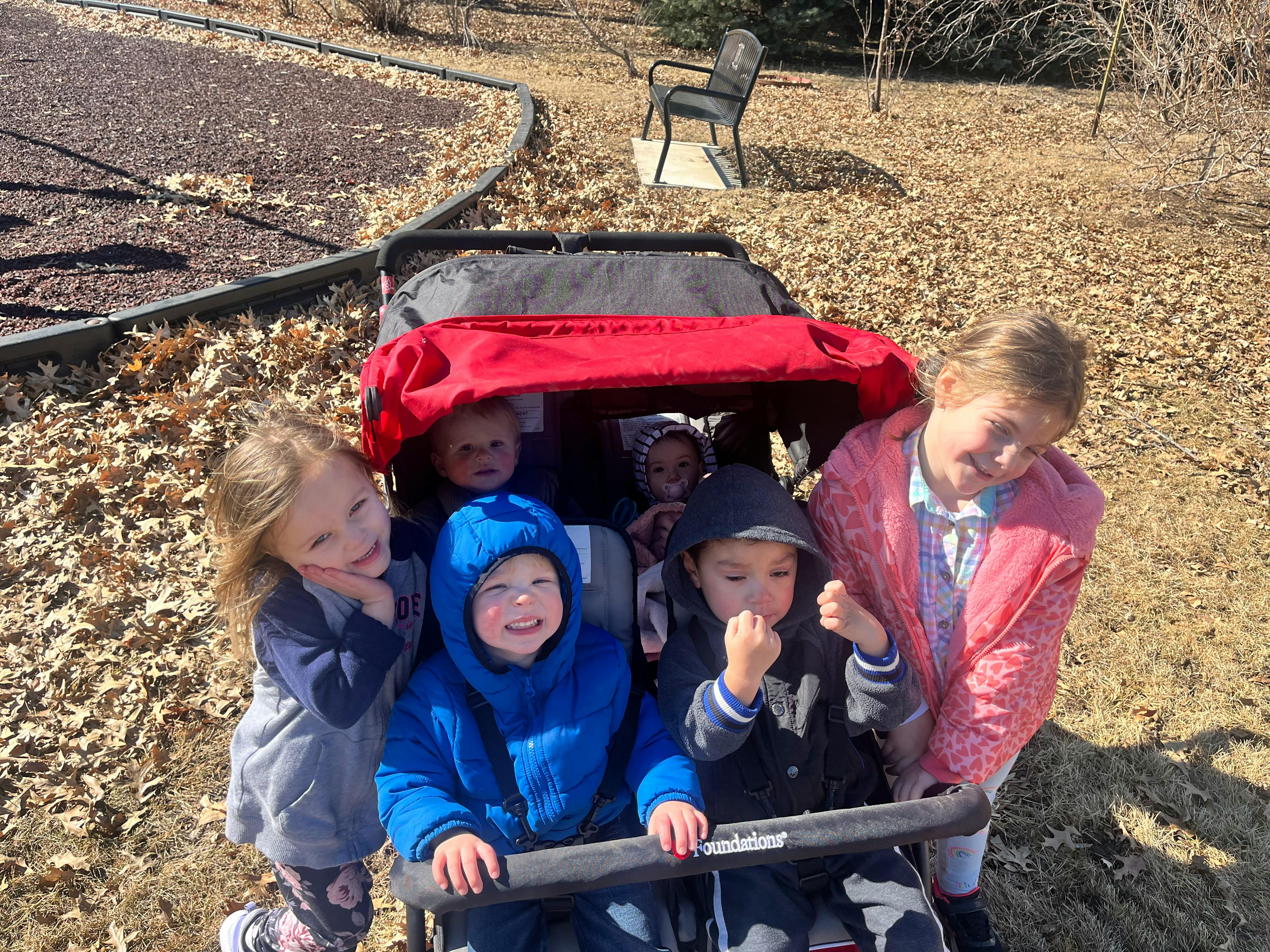 Children in and around a red wagon