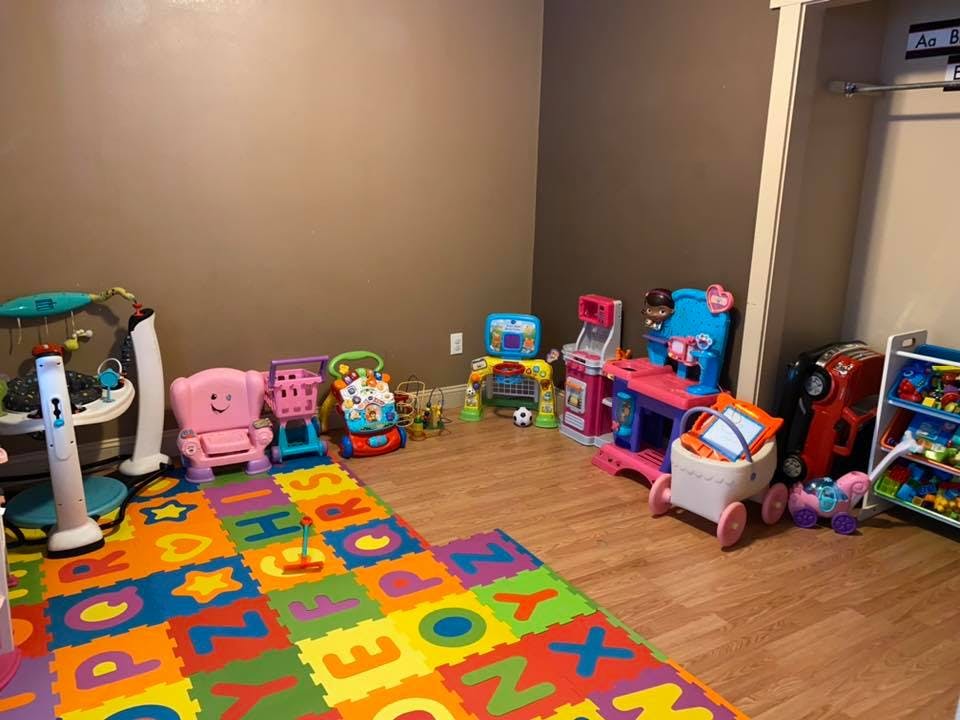 Playroom with a colorful alphabet mat and various toys