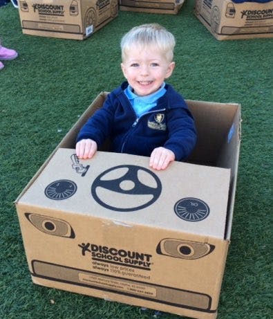 Child in a cardboard box car