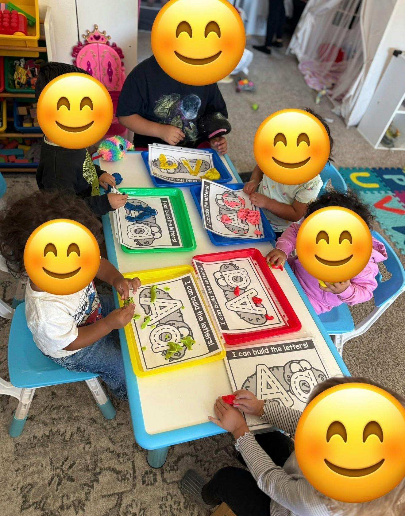 Children learning to build letters with playdough on trays