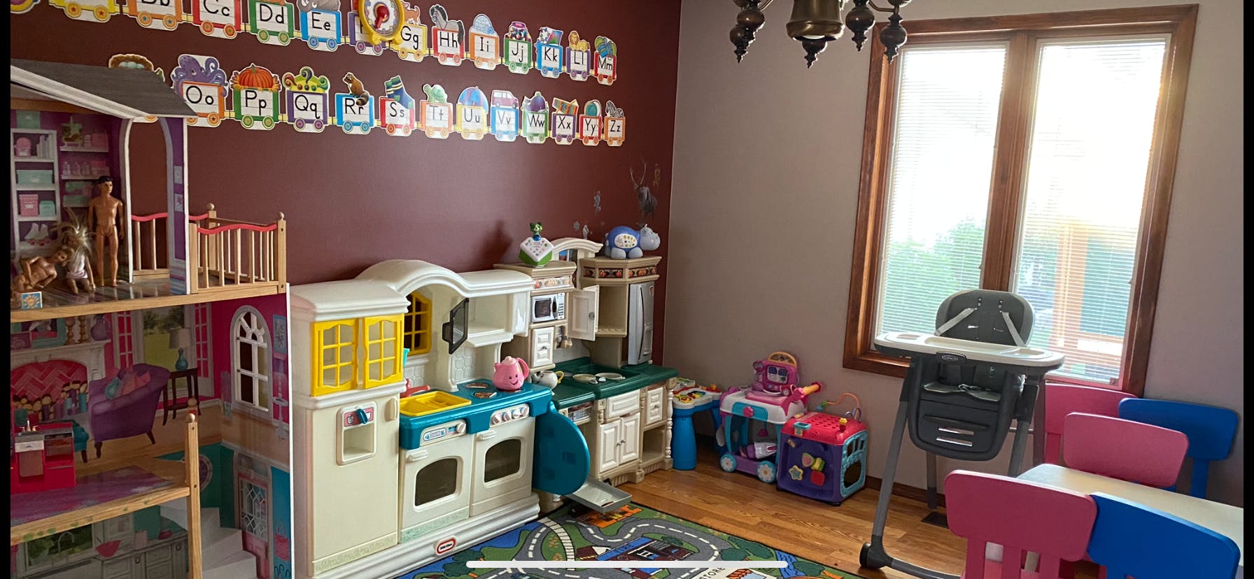 Playroom with dollhouse, toy kitchen, and high chair