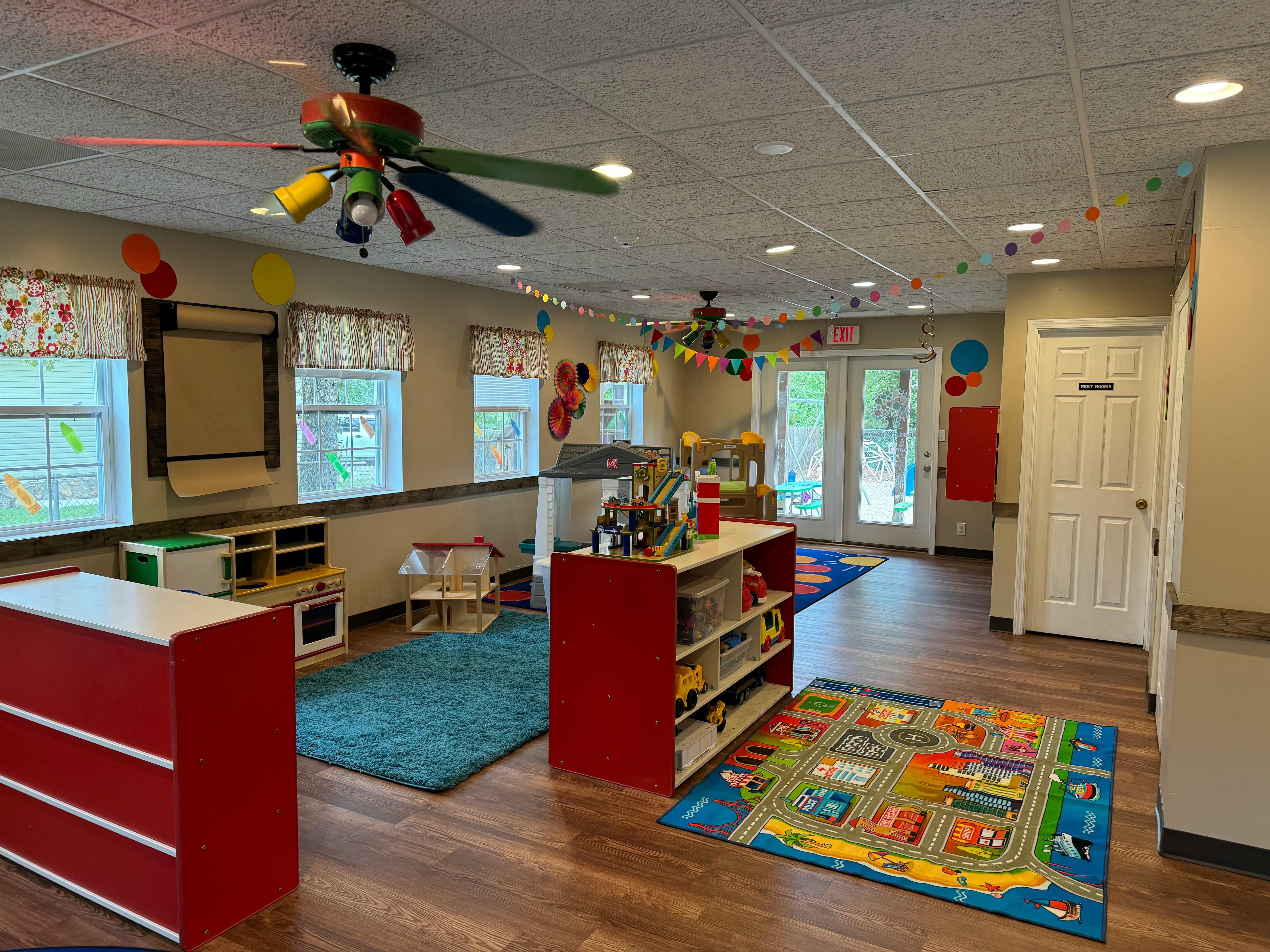 Playroom with colorful rugs, shelves, and ceiling fans
