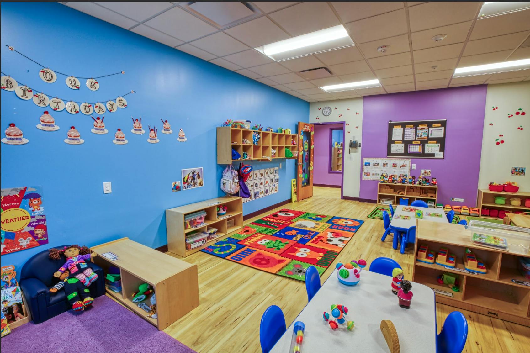 Colorful classroom with small tables, chairs, and storage shelves