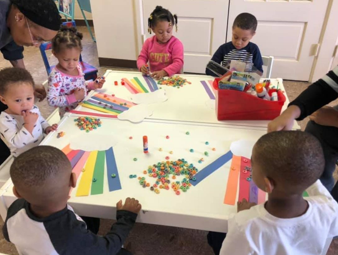 Children and adults doing crafts at a table